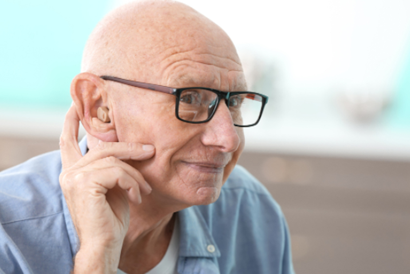 An older man wearing a hearing aid